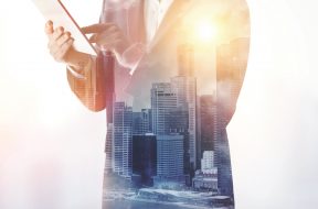 double exposure of city and business man using digital tablet